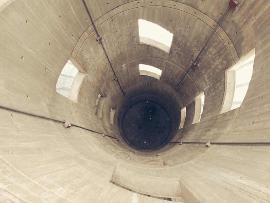 Echo chambers: życie w bańce informacyjnej przedstawione jako wnętrze cylindrycznego szybu z oknami, symbol izolacji opinii.