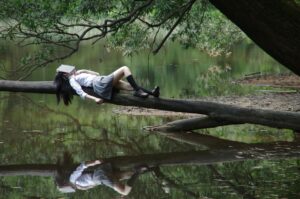 Prokrastynacja przyczyny: woman lying on tree near awter